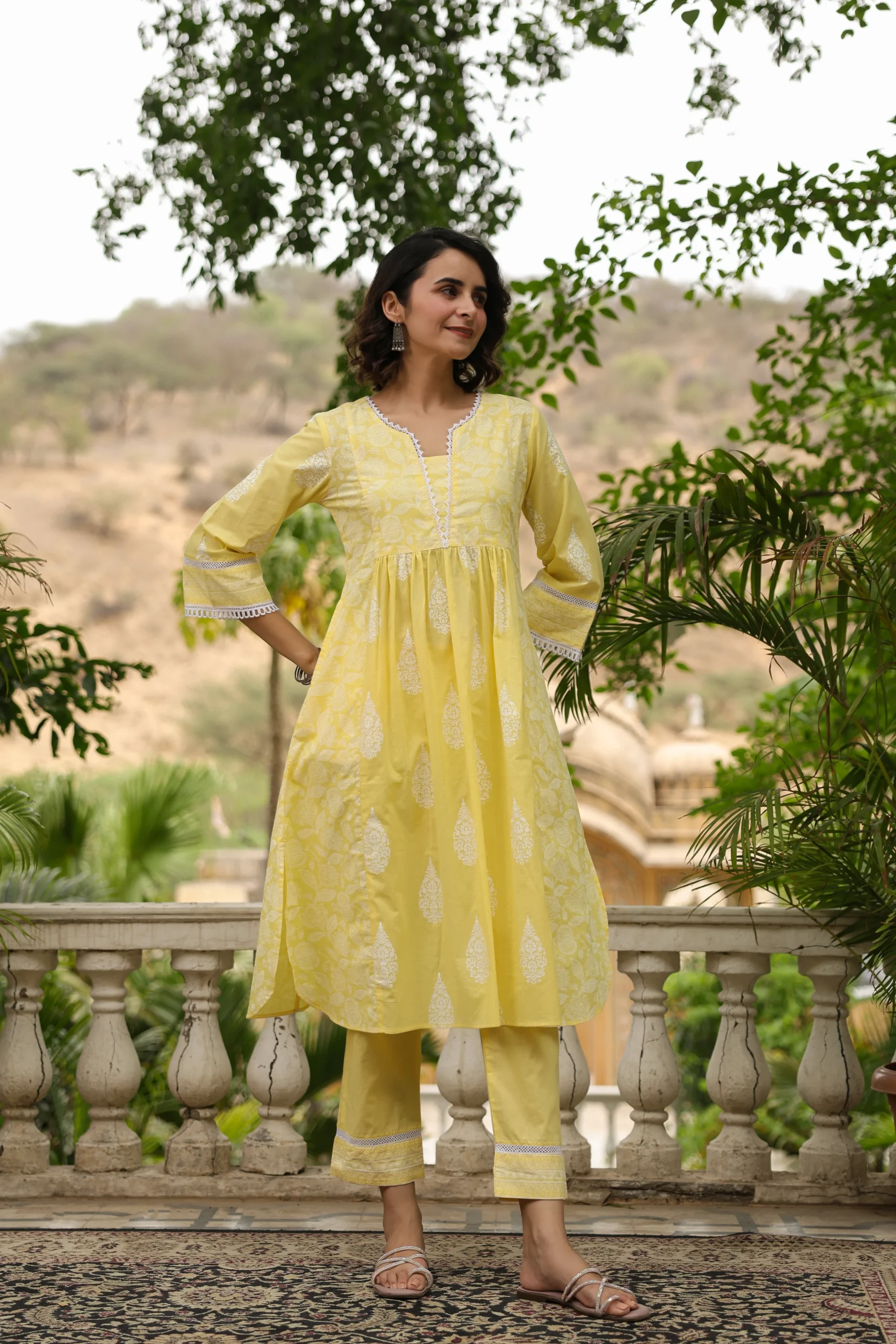 Brighten up your ethnic wardrobe with this yellow cotton kurta set, featuring delicate white prints, lace detailing, and matching straight pants. Perfect for festive days and casual outings